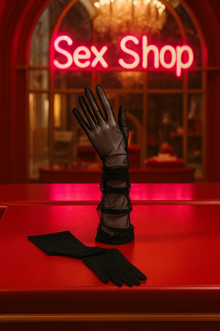 Black tulle sheer  gloves on a red counter with a neon 'Sex Shop' sign in the background